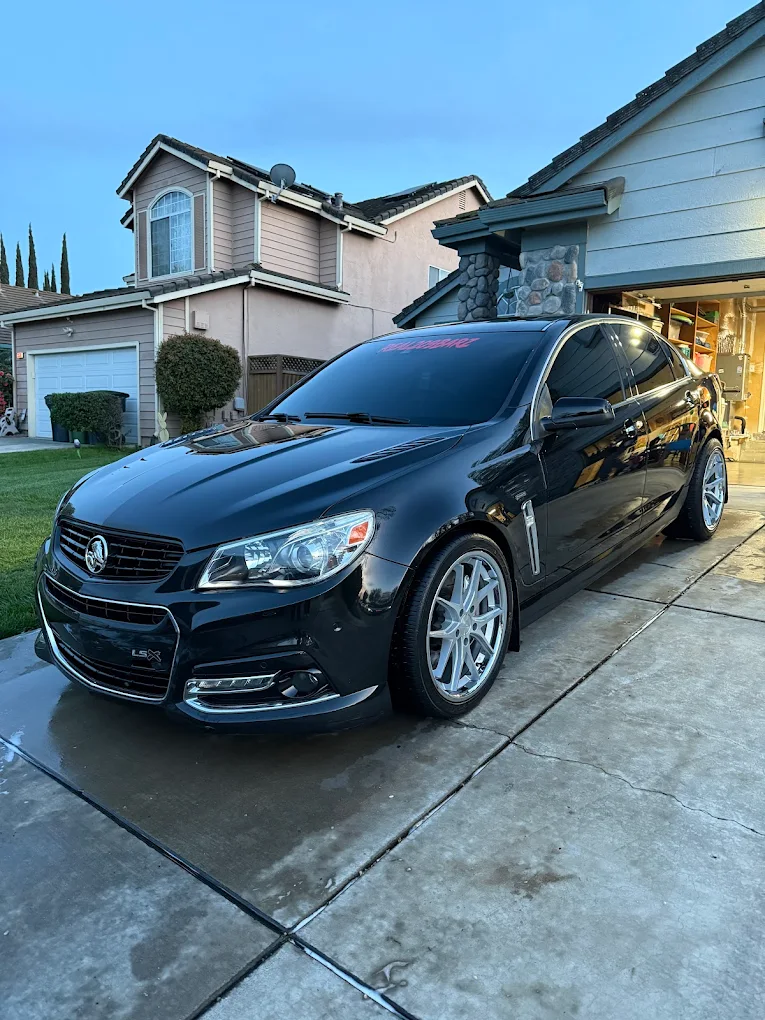 Freshly washed black sedan in driveway
